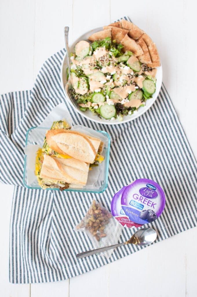Dannon Light & Fit Greek yogurt, sandwich, and salad on a table