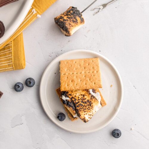 Stacked s'mores with toppings in the background