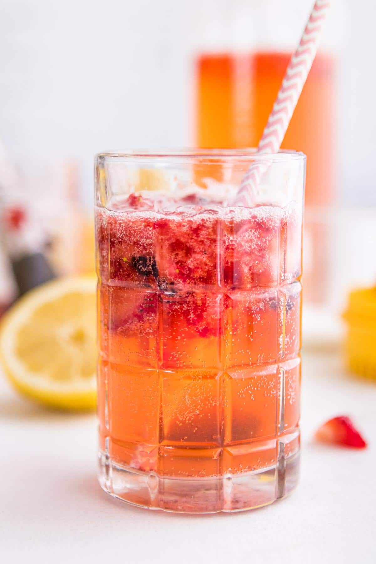 sparkling berry lemonade in a glass with a pink straw