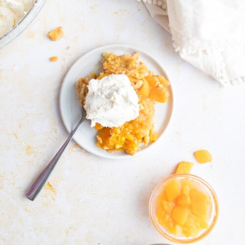 holding the handle of a cast iron skillet with peach cobbler in it