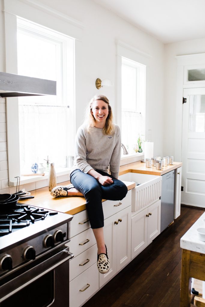 woman sitting on countertop in kitchen