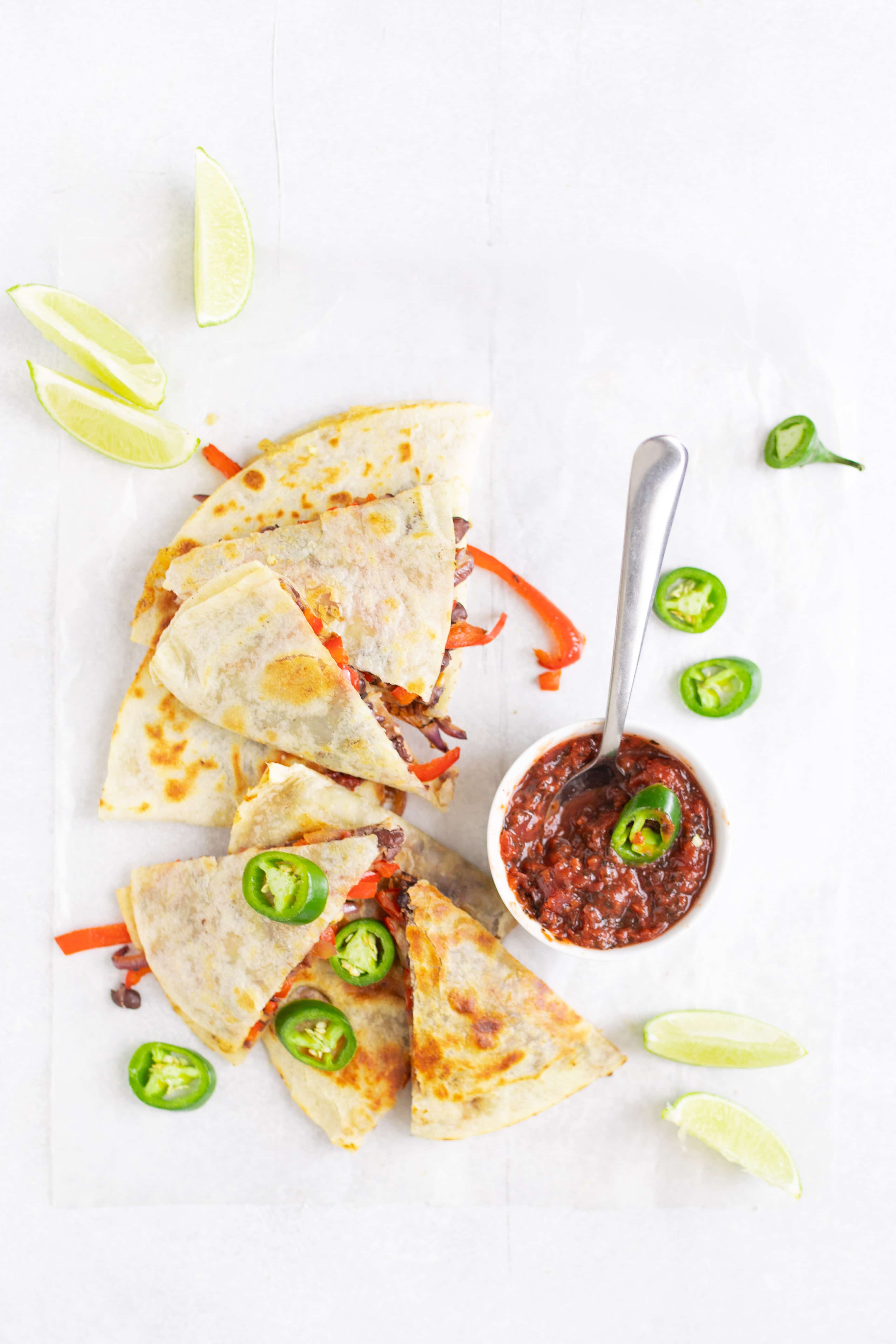 black bean & vegetable quesadilla on table with salsa and toppings