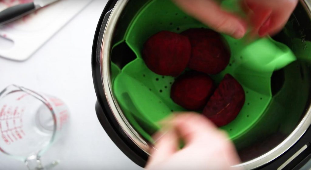hands lowering beets into an Instant Pot
