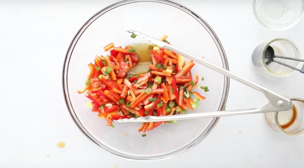 red bell pepper and green onions in a glass bowl