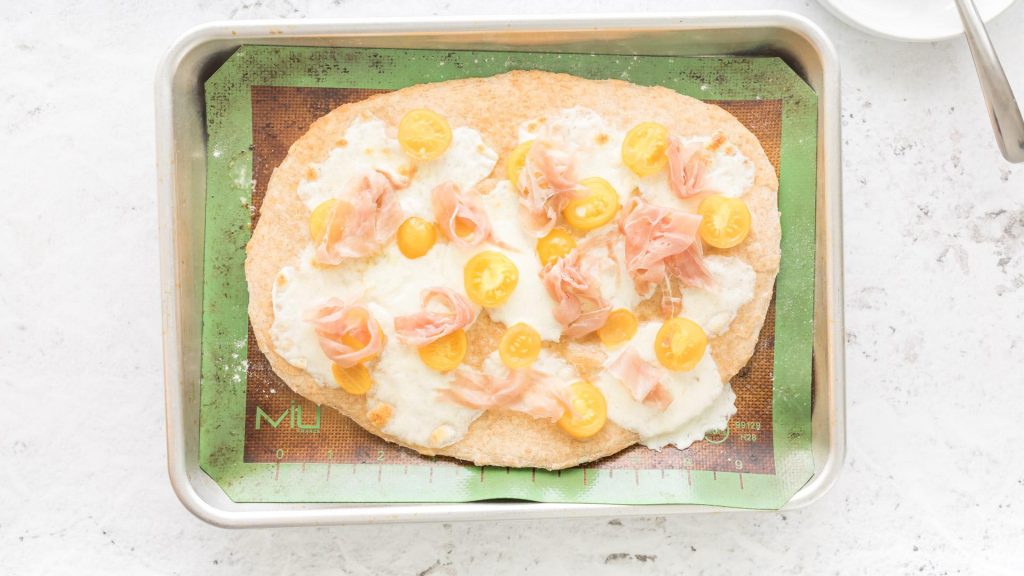 baked pizza caprese on a baking sheet