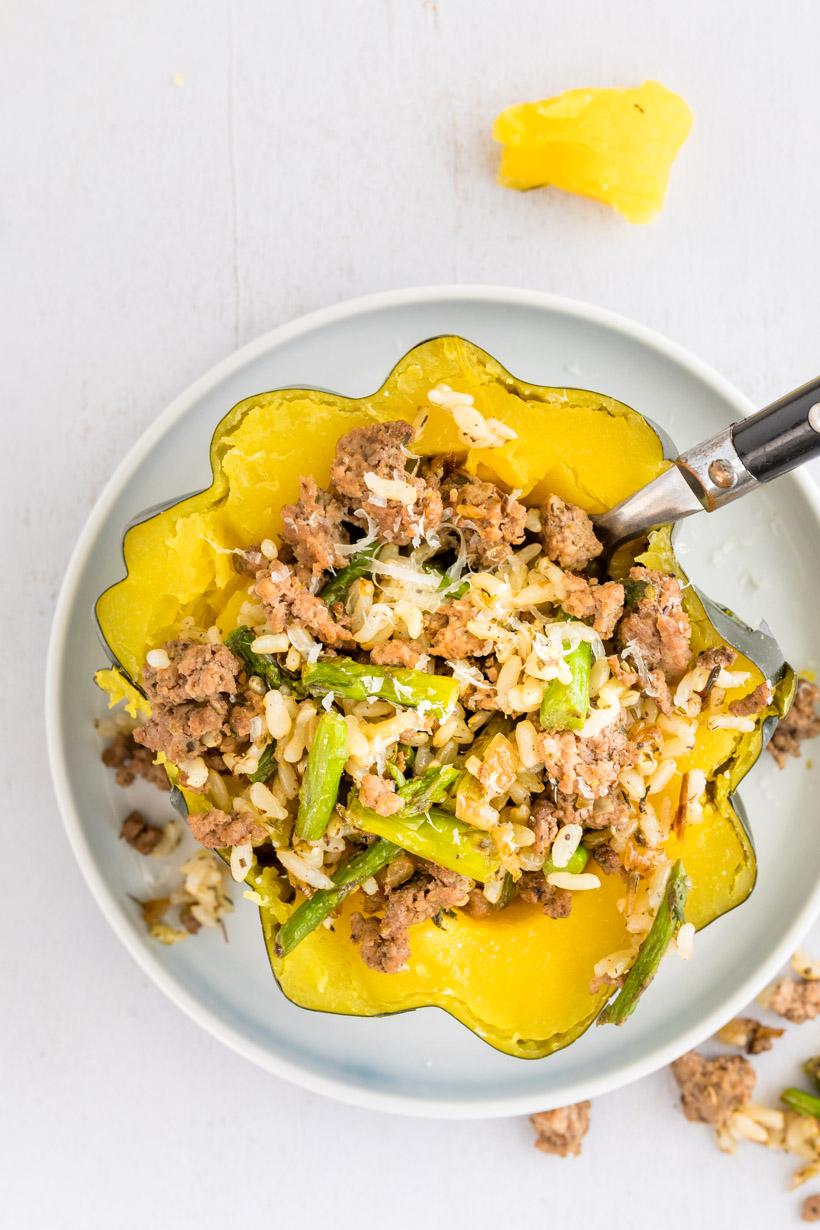 stuffed acorn squash recipe with a fork in it, on a plate