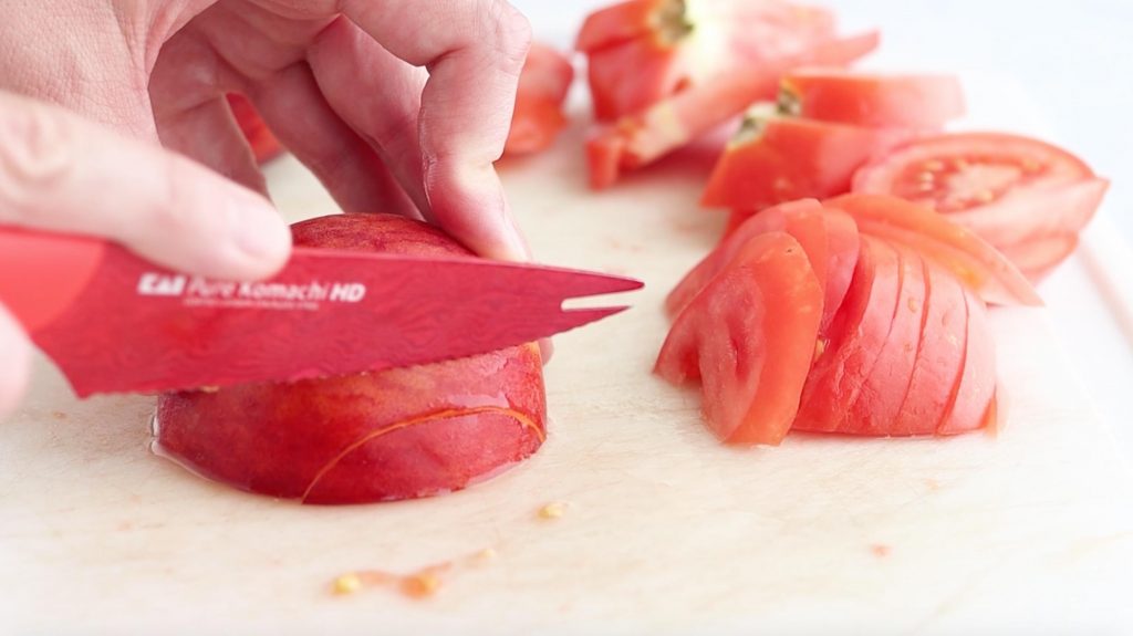 slicing tomatoes for pan seared salmon and summer salad