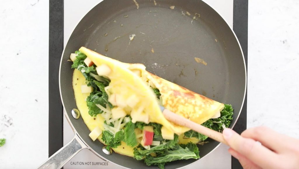 folding an apple omelette in a pan