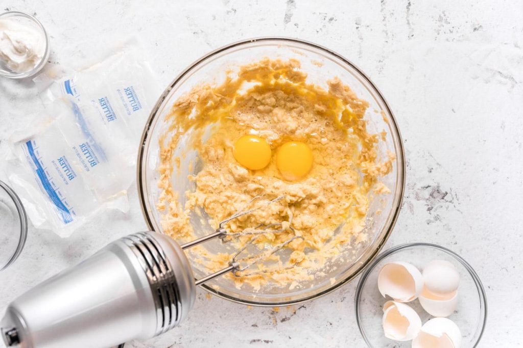 eggs in creamed sugar and butter in a glass mixing bowl