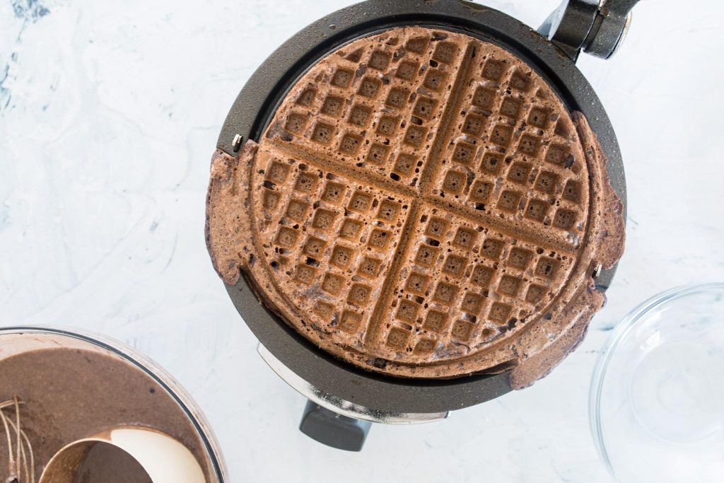 cooked dark chocolate waffle in a waffle iron